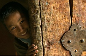 a child smiling behind the door